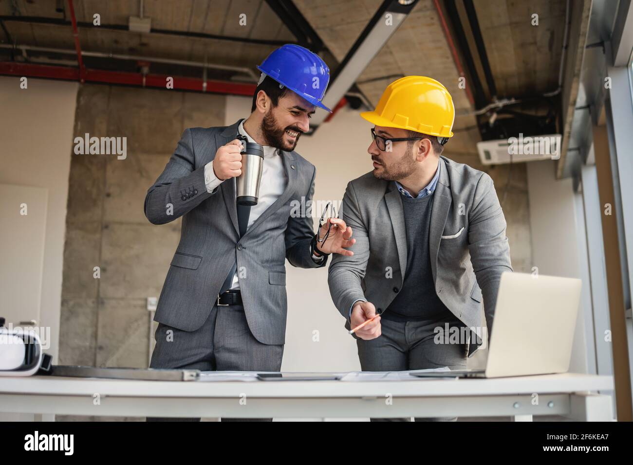 Two architects standing in building in construction process and talking about big project. Stock Photo
