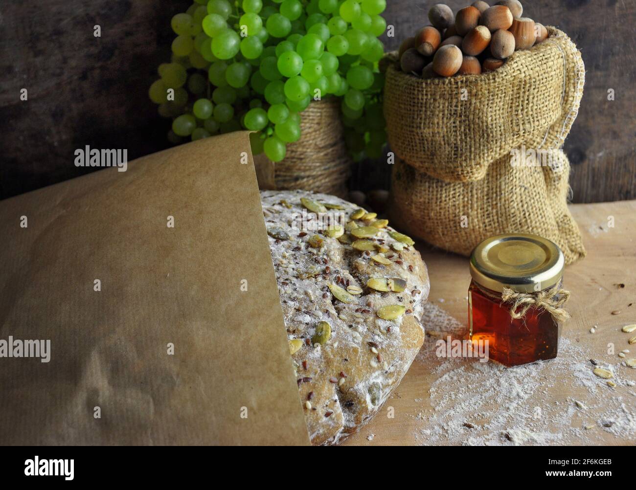 Bread, grapes, nuts, honey, rustic wood background Stock Photo