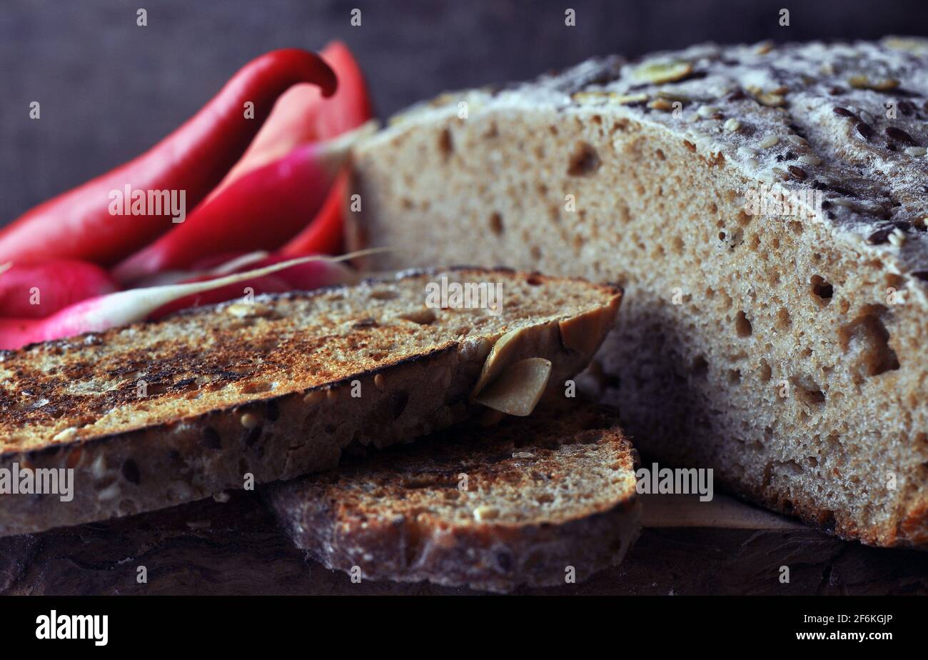 Multigrain Bread with Flax Seeds and Sesame on Wooden Board. Stock Photo