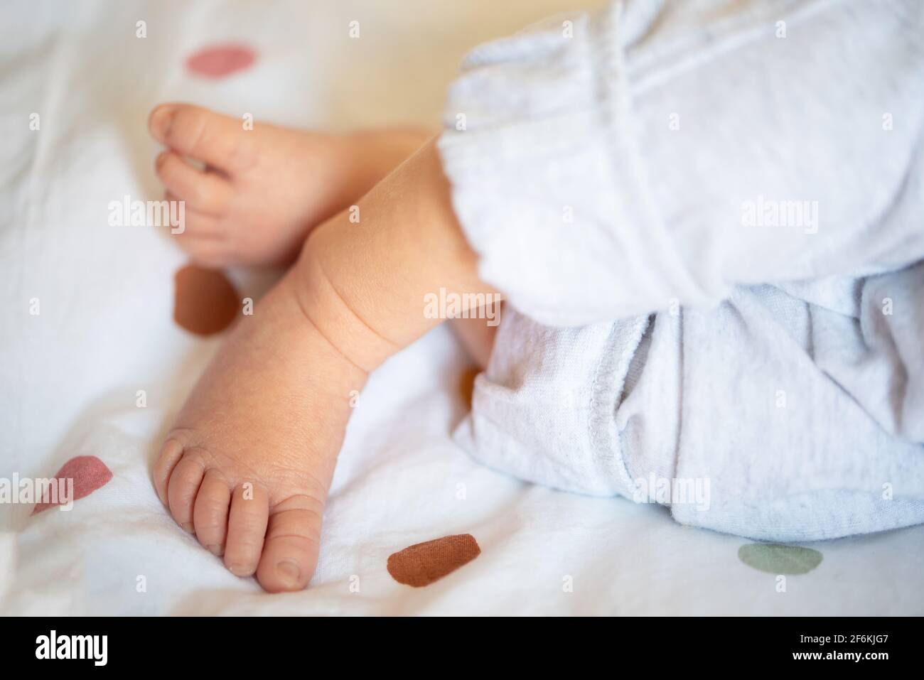 close-up of legs and feet of newborn baby resting on bed Stock Photo