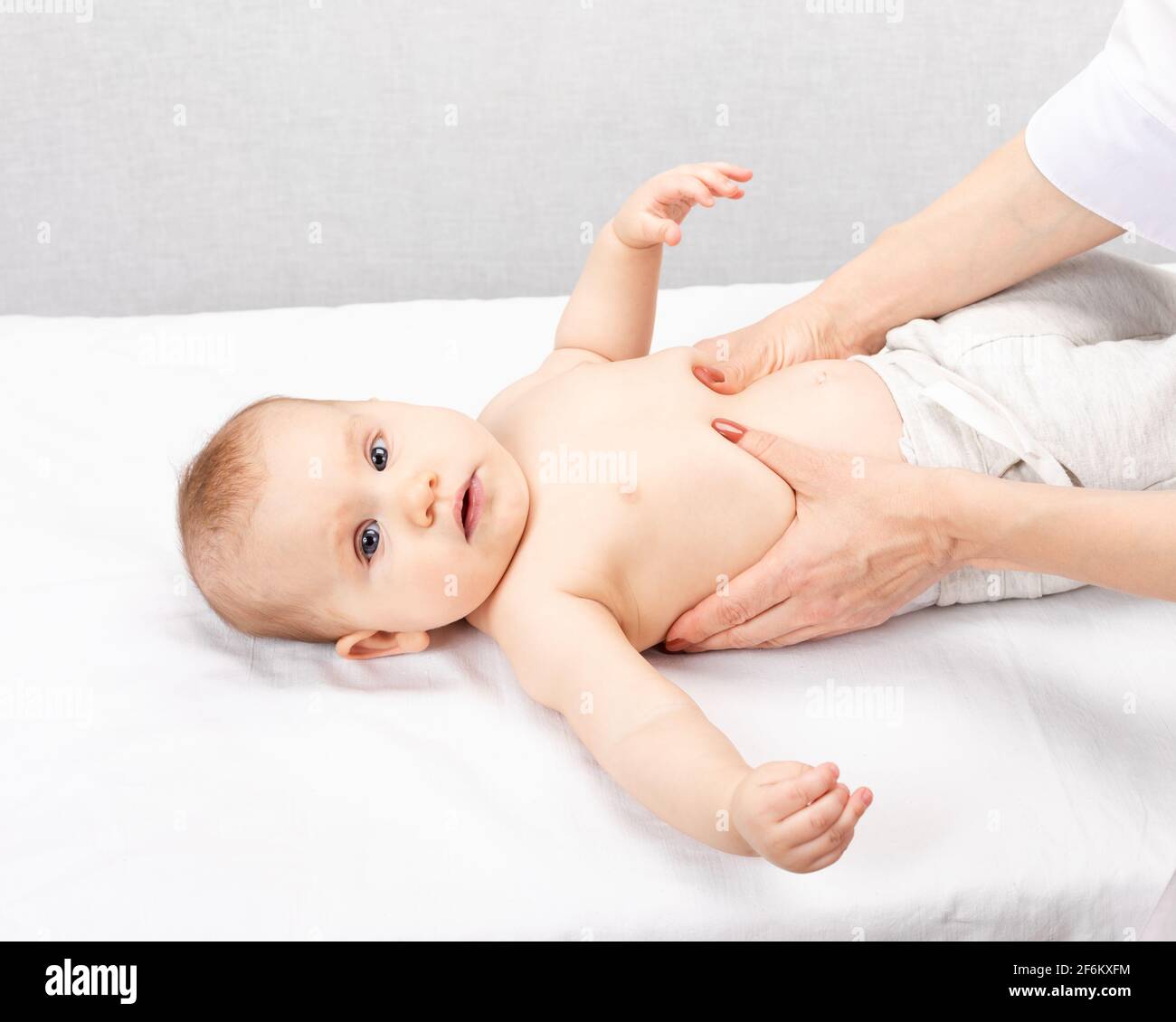 Six month baby girl receiving massage therapy in pediatric clinic