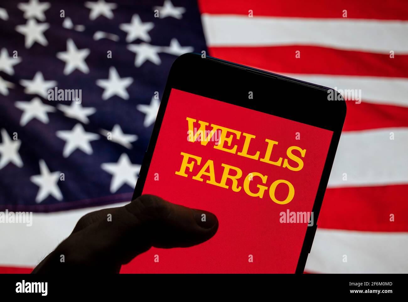 In this photo illustration the American multinational financial services company Wells Fargo logo is seen on an Android mobile device with United States of America (USA), commonly known as the United States (U.S. or US), flag in the background. Stock Photo