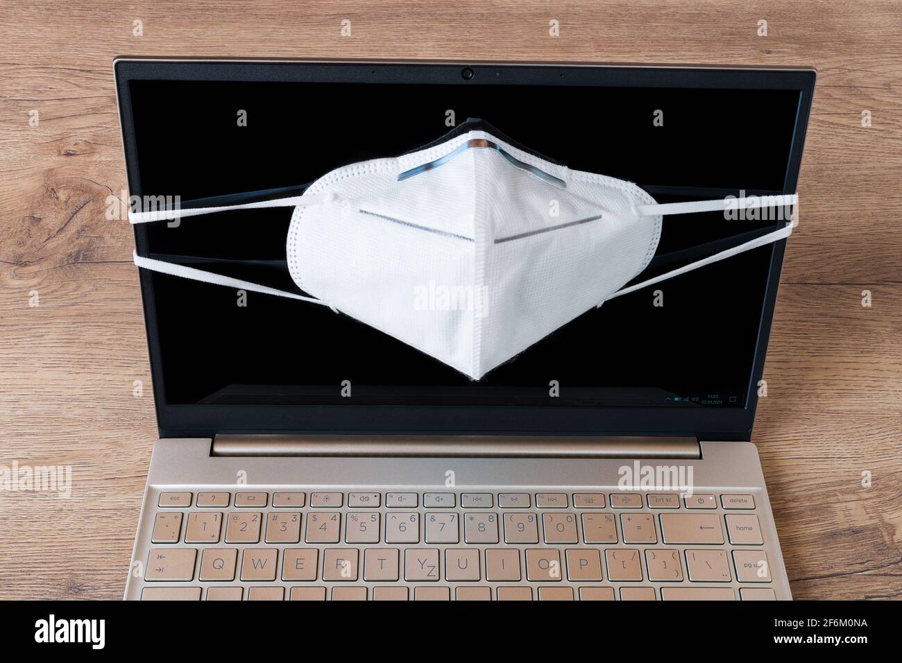 White face respirator on personal laptop display. Coronavirus and ...