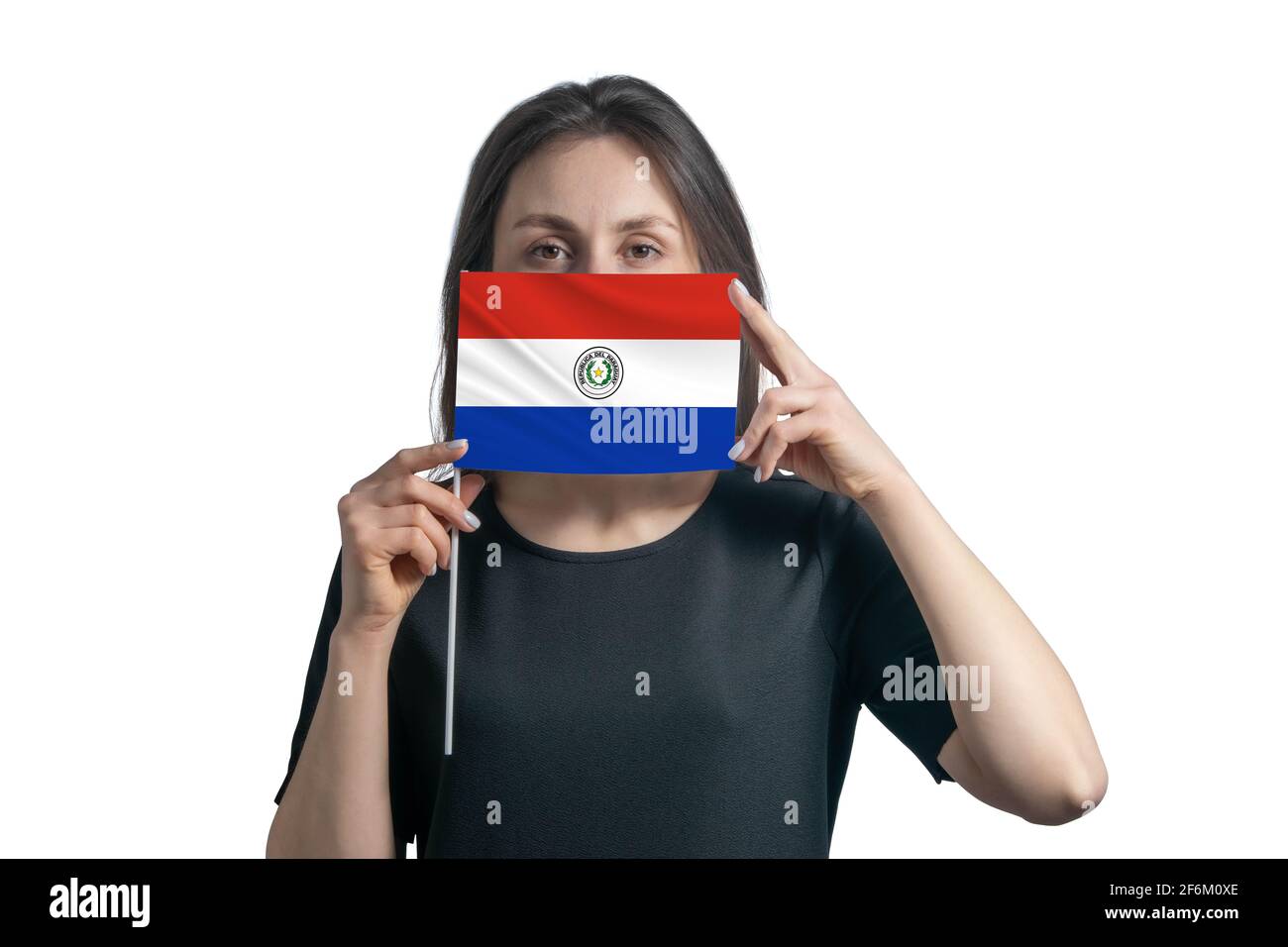 Happy young white woman holding flag Paraguay flag and covers her face with it isolated on a white background. Stock Photo