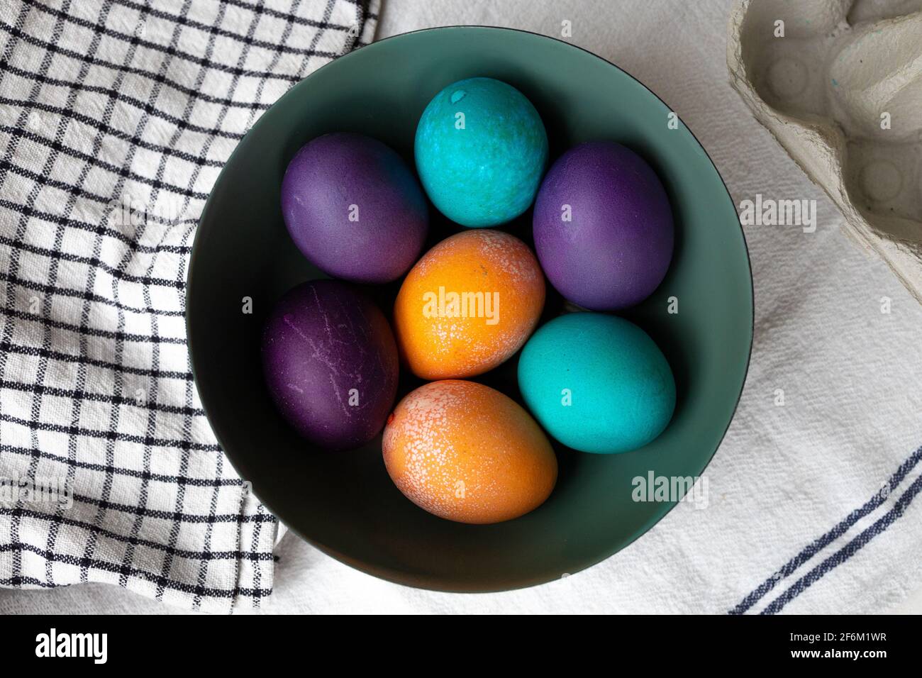 Easter eggs in a bowl in blue, turquoise, purple, and orange. Stock Photo