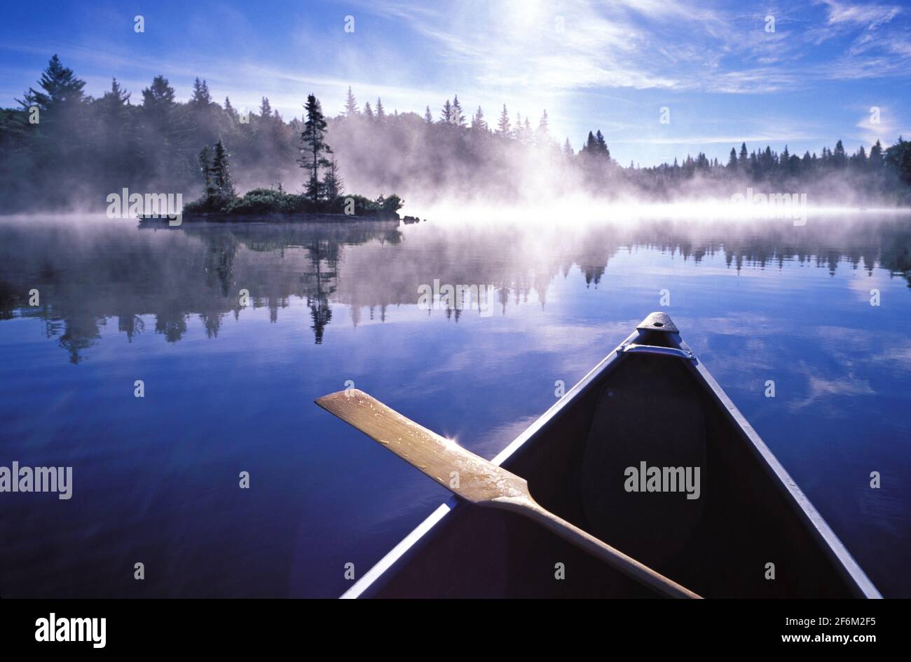 Canada, Ontario, Algonquin Provincial Park, bow of canoe on a lake with morning mist rising Stock Photo