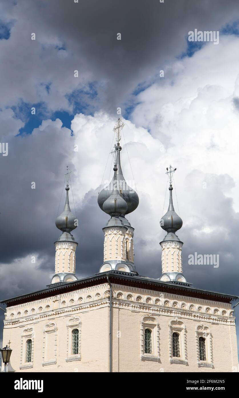 Domes of a Christian church rising into a gloomy sky. High, beautiful white-stone tower of the temple with crosses at the top. A panorama that embodies freedom, independence and love for God. Stock Photo