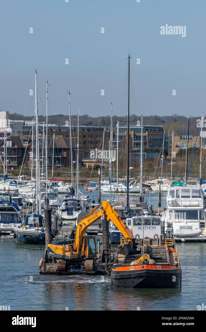 a working vessel or barge driving piles into the seabed to make new moorings and pontoons in lymington harbour Stock Photo
