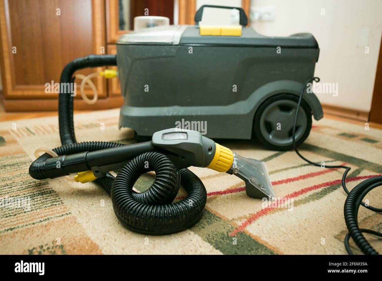 The process of cleaning carpets with a steam vacuum cleaner. The carpet cleaning equipment is ready for use. Stock Photo