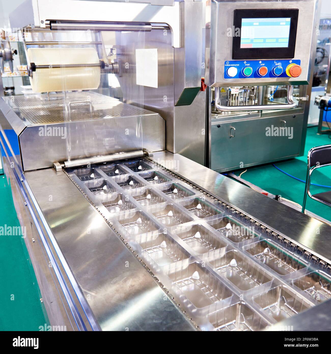 Conveyor at food factory for packing plastic containers Stock Photo