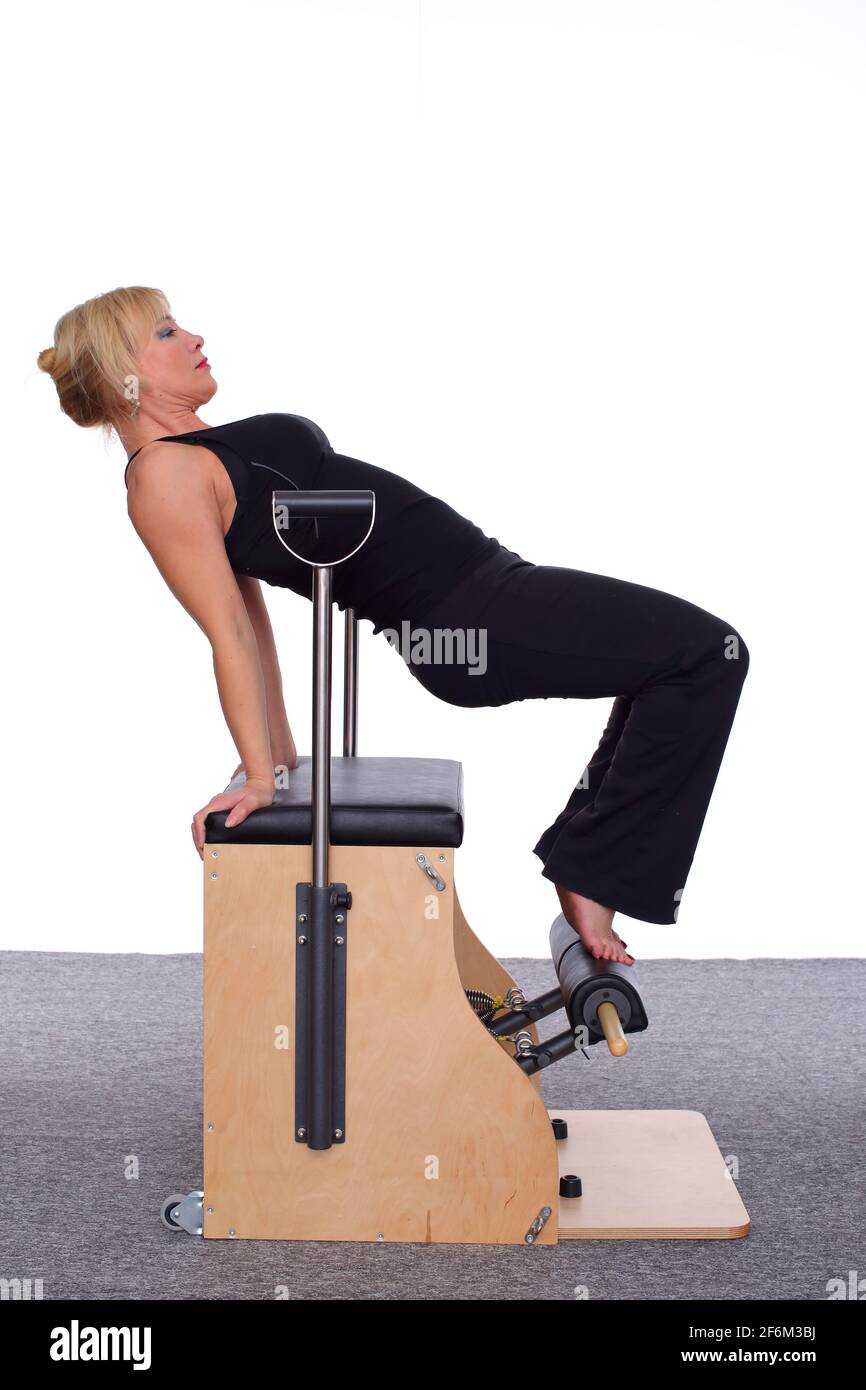 A 50yearold trainer practices Pilates on an elevator chair, bending