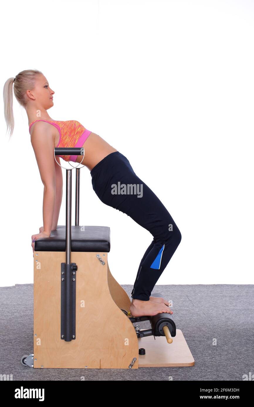 A 20yearold trainer practices Pilates on an elevator chair, bending