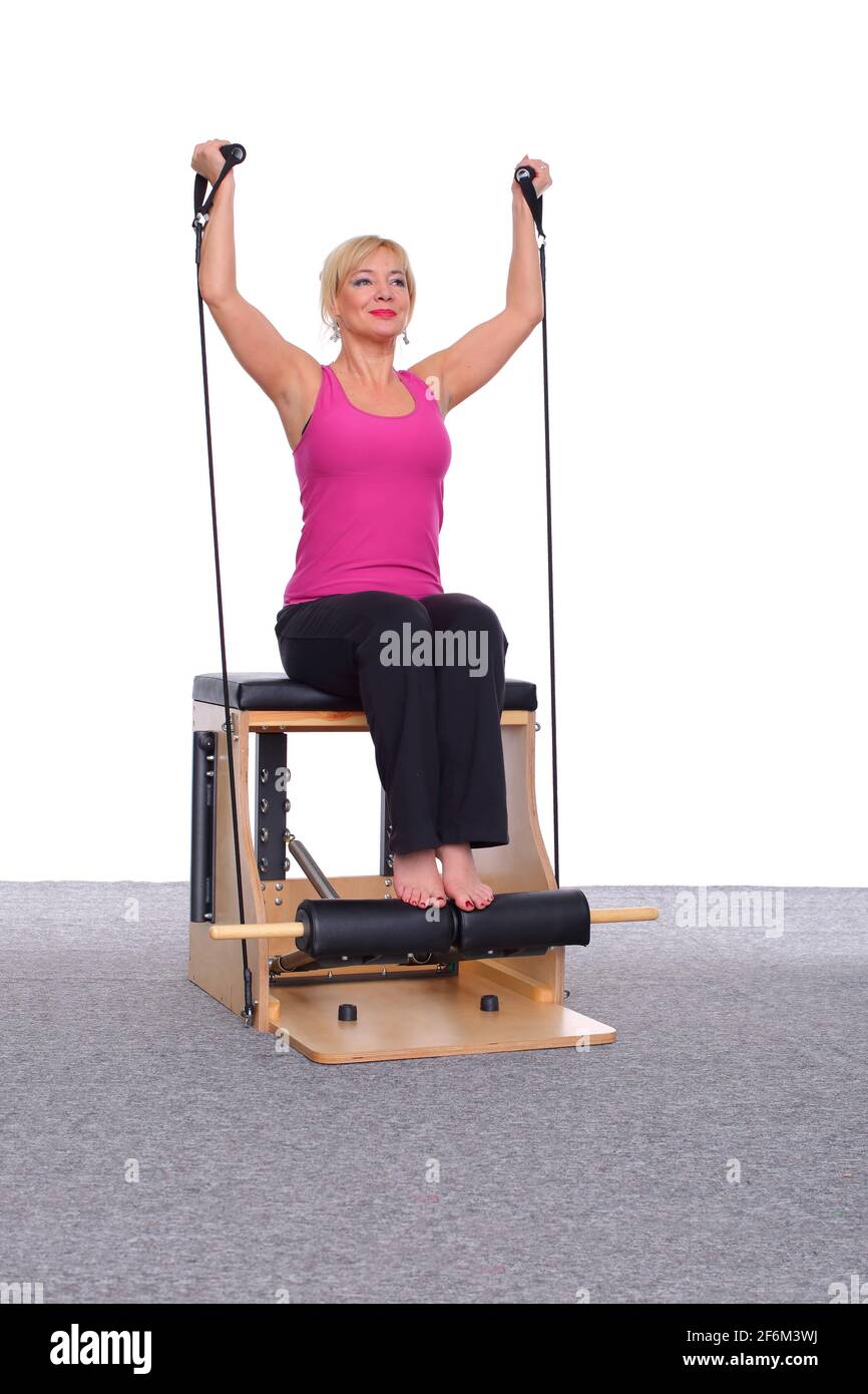 A 50yearold trainer exercises Pilates on an elevator chair with the