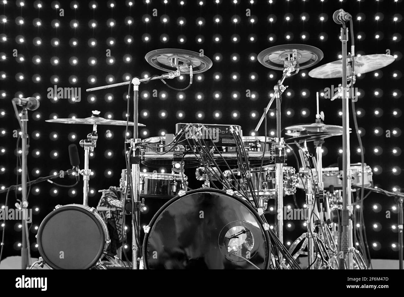 Drum kit with different types of drums on the stage with lights on the  background in black and white Stock Photo - Alamy