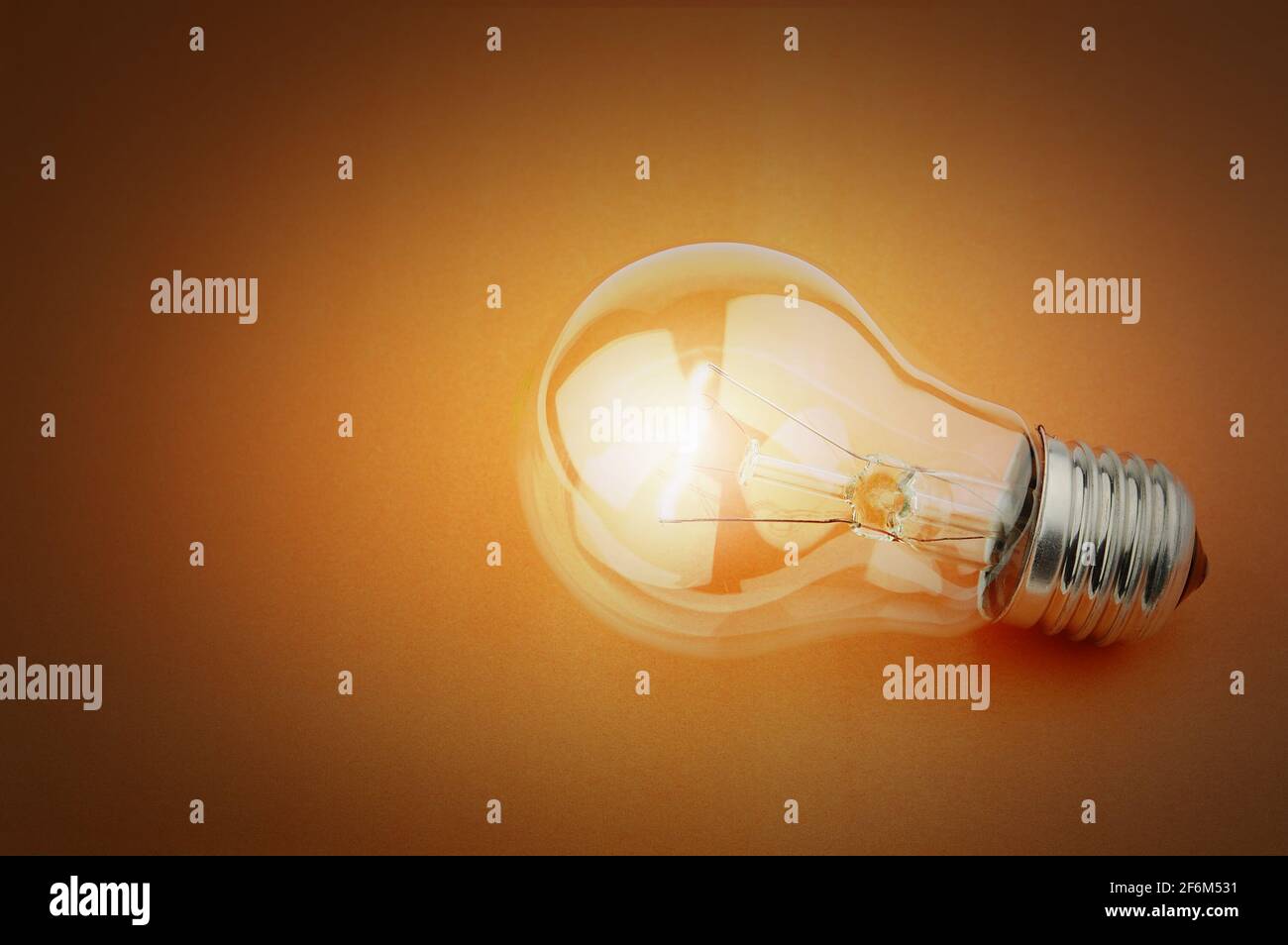 Electric light bulb on a orange background Stock Photo