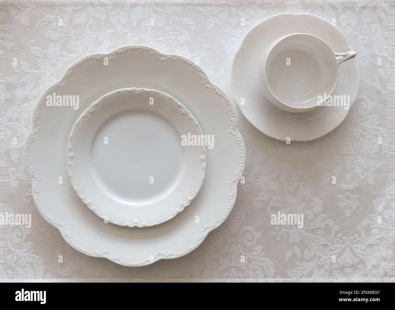 White Porcelain Place Setting on White Tablecloth Stock Photo