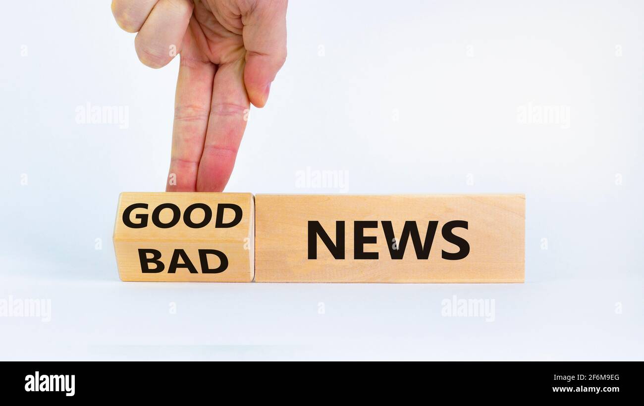Good or bad news concept. Businessman turns a block and changes words ...