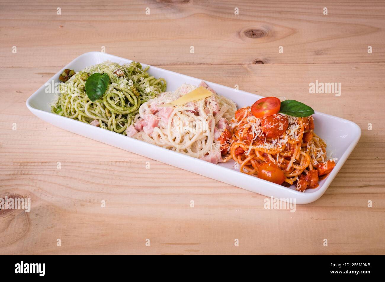 Delicious three-color pasta with alfredo, tomatoes and basil. red, green and white. Stock Photo