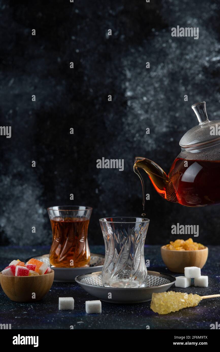 Vertical photo of tea table. Pouring tea to the glass Stock Photo