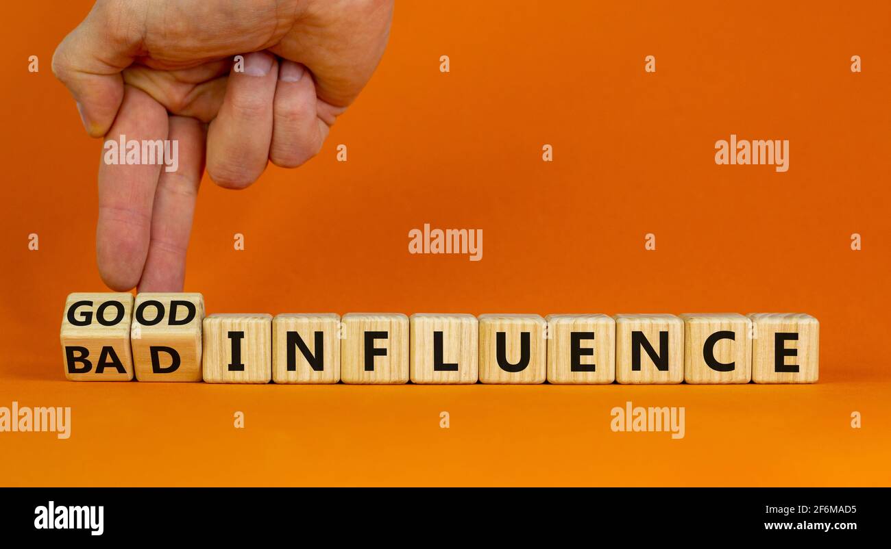 Good or bad influence symbol. Businessman turns cubes and