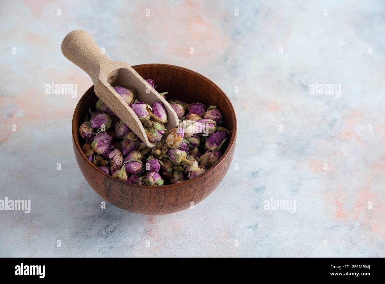 Dry flowers in wooden bowl over white background Stock Photo