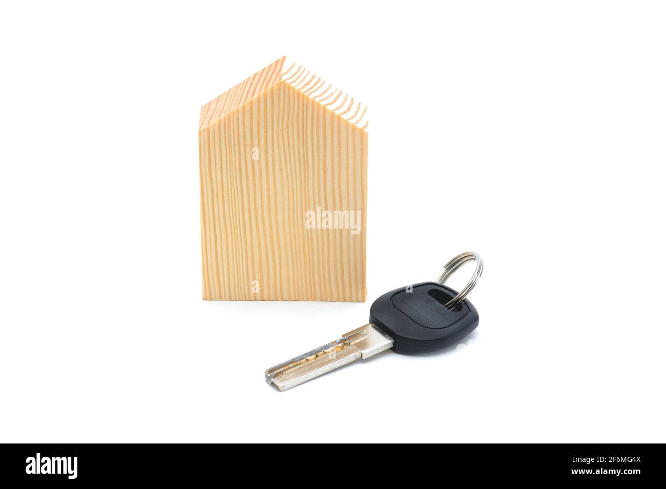 Apartment key and wooden model of house. Isolated over white background. Concept of new housing, mortgage, housewarming. Stock Photo