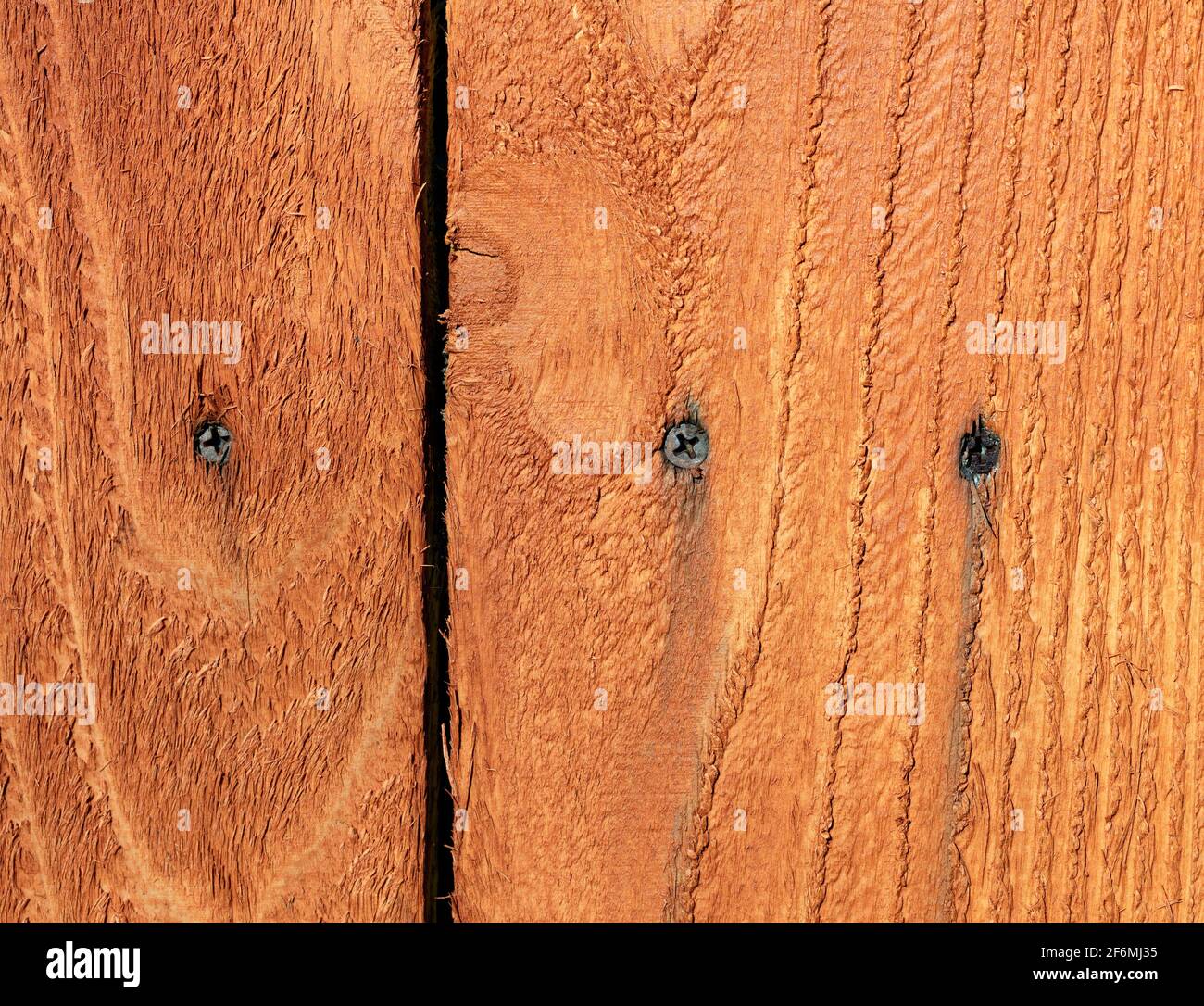 Metal screws starting to rust in outdoor wooden cedar fence Stock Photo