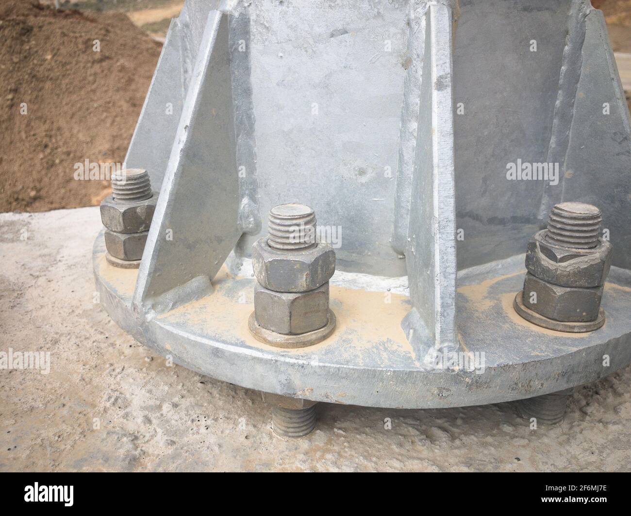 Metal pillar bolted to concrete foundation with anchor bolts Stock