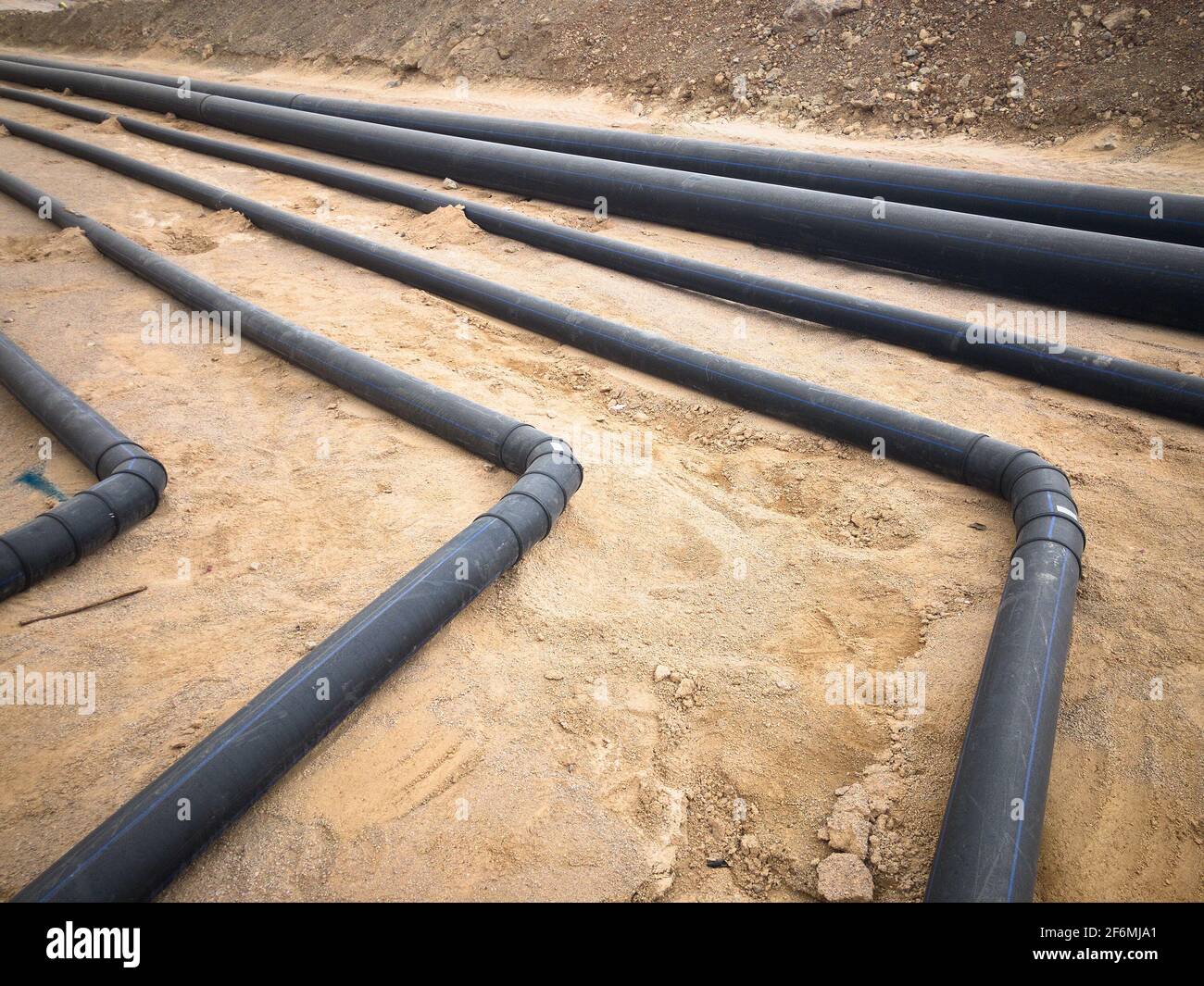 Black plastic water pipes laid on sand foundation Stock Photo Alamy