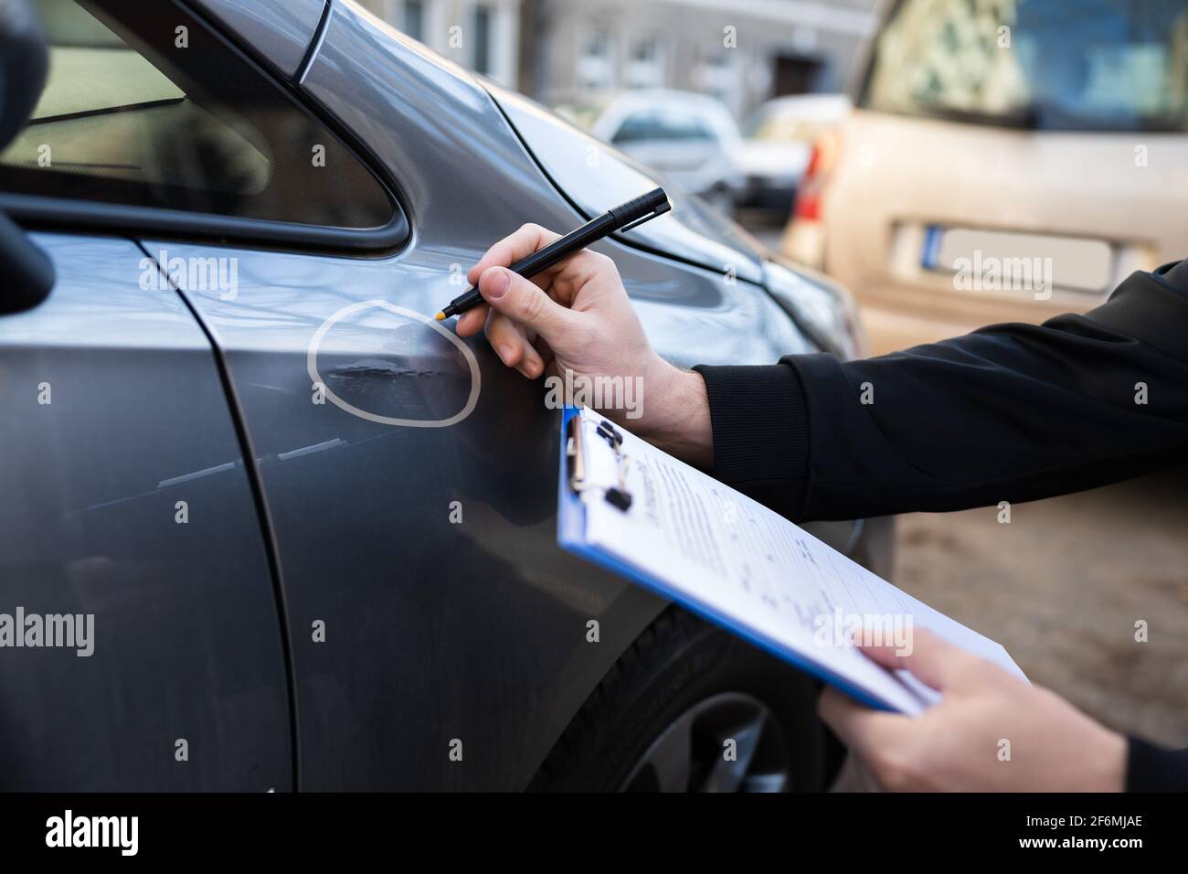 Insurance Agent Or Adjuster Inspecting Car After Accident Stock Photo