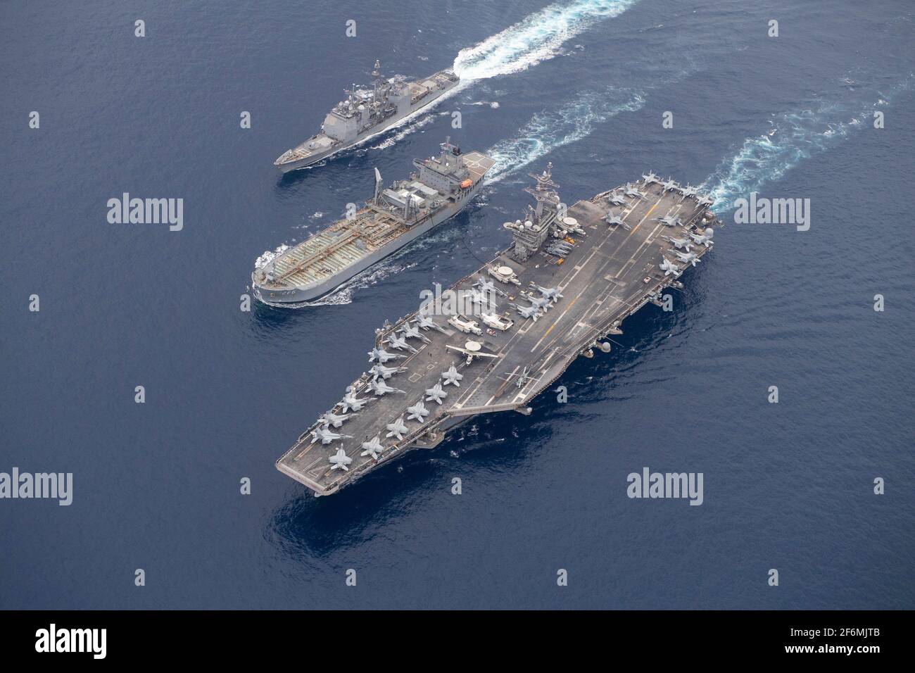 Uss Theodore Roosevelt, United States. 31st Mar, 2021. The U.S. Navy Nimitz-class, nuclear-powered, aircraft carrier USS Theodore Roosevelt, right, is refueled by the Royal Australian Navy ship HMAS Sirius, center, while the Ticonderoga-class guided-missile cruiser USS Bunker Hill transits alongside during a replenishment-at-sea March 31, 2021 on the Indian Ocean. Credit: Planetpix/Alamy Live News Stock Photo