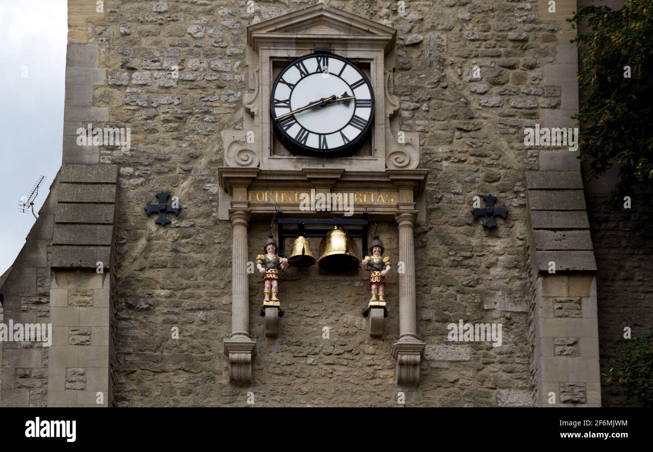 Close-up of a clock in a stone wall in Carfax Tower, Oxford with two automaton and brass bells Stock Photo
