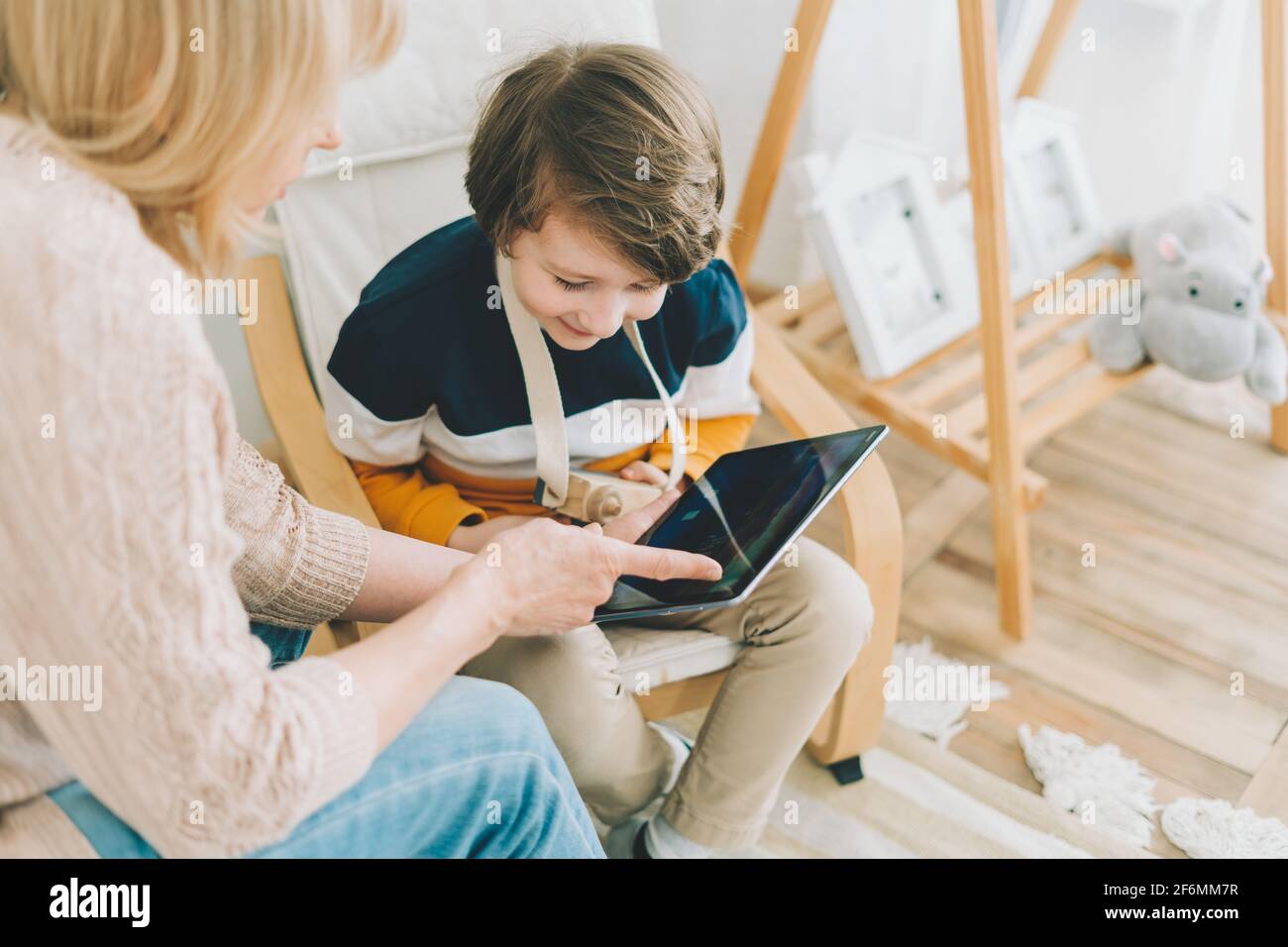 Mother with son in children's room, looking at tablet  Stock Photo
