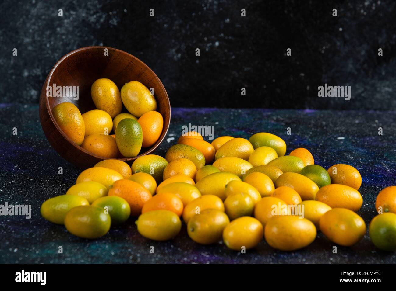 Pile of fresh juice kumquats on blue background Stock Photo