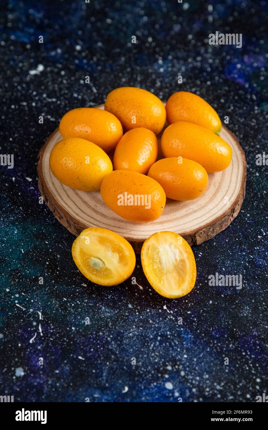 Vertical photo of kumquats over wooden board Stock Photo