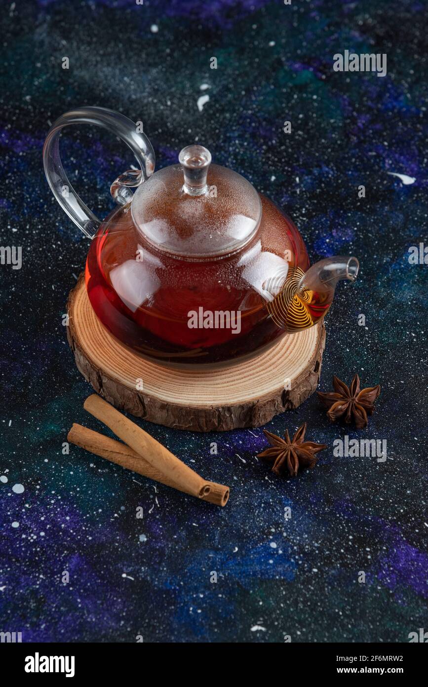 Vertical photo of Glass tea pot with cinnamon on wooden board Stock Photo