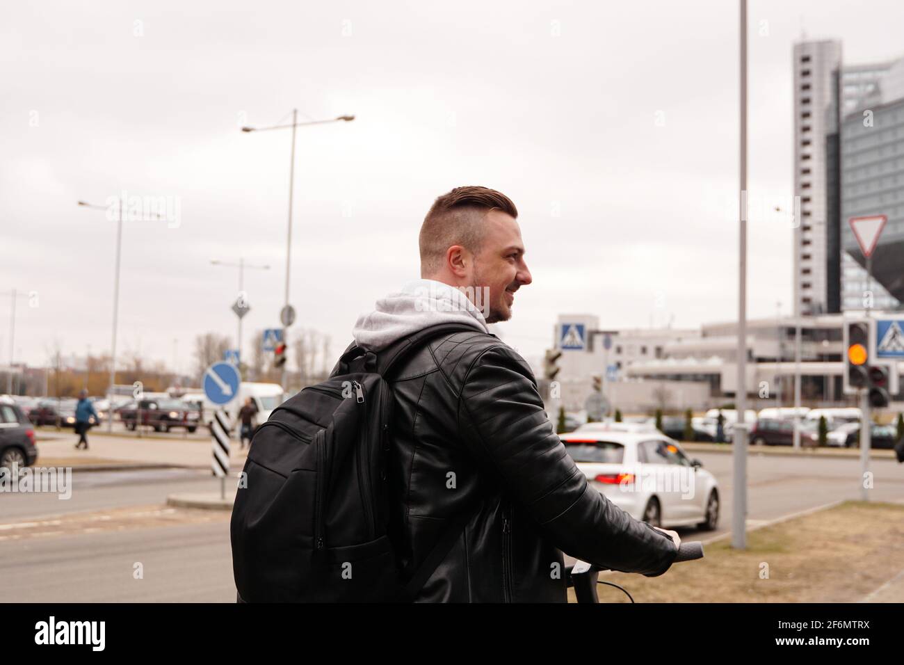 Young man with backpack on his back riding on scooter Stock Photo