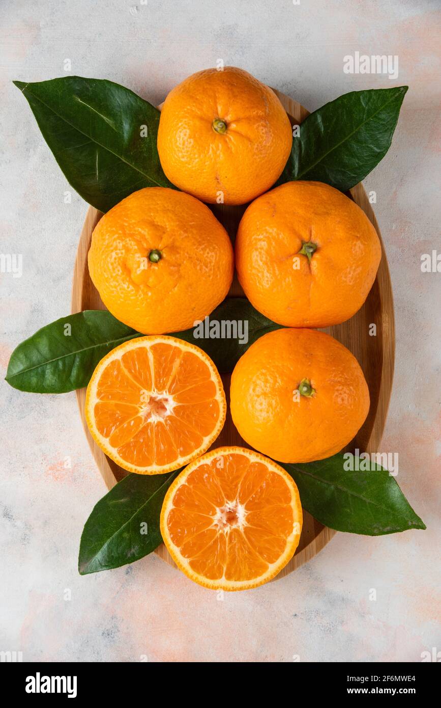 Whole or half cut clementine mandarins plate over background Stock