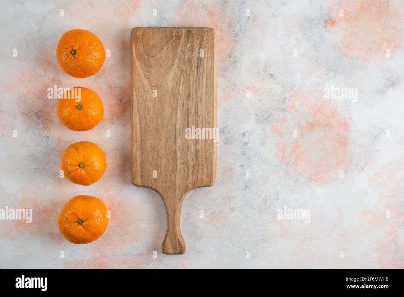 Fresh clementine mandarins in a row behind of wooden board Stock Photo