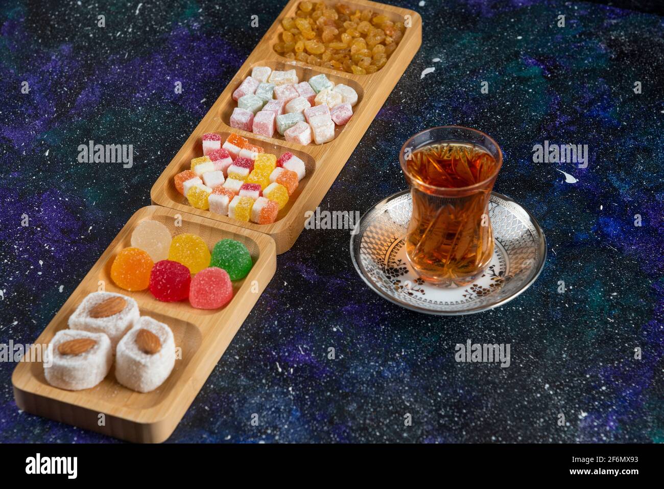 Delicious Turkish delights with tea on colorful background Stock Photo