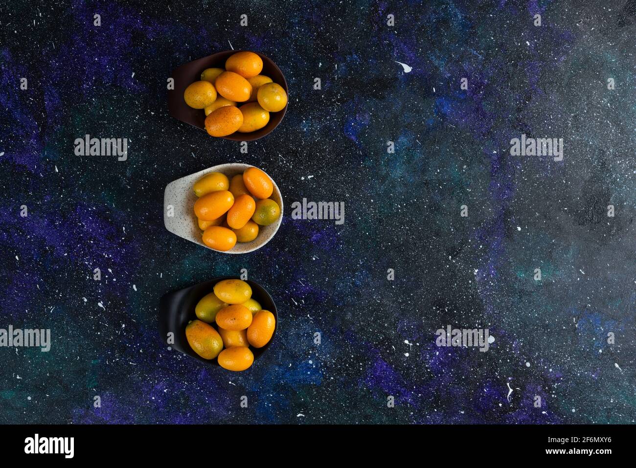 Top view of fresh kumquats on blue background, Vide angle photo Stock Photo