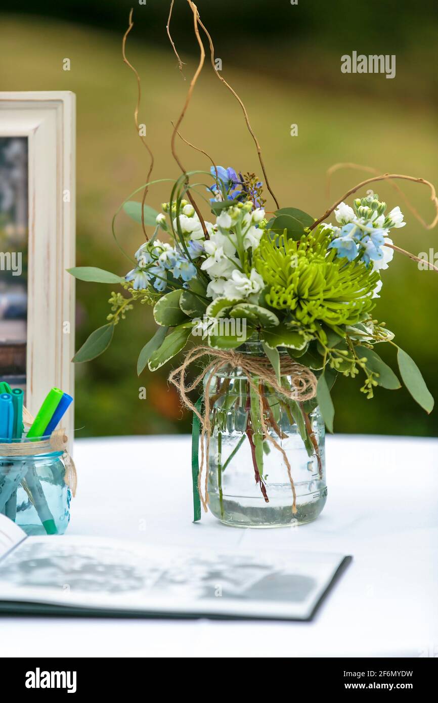 Flowers in a mason jar as decor for a registry table at an outdoor wedding  with a sign in book Stock Photo - Alamy, image size:866x1390