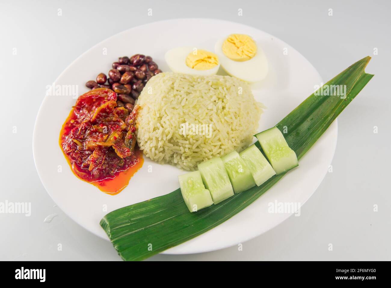 Nasi lemak with pandan rice (Malay fragrant rice dish cooked in coconut milk and pandan leaf) with recipe ingredients. The best spicy anchovies yummy. Stock Photo