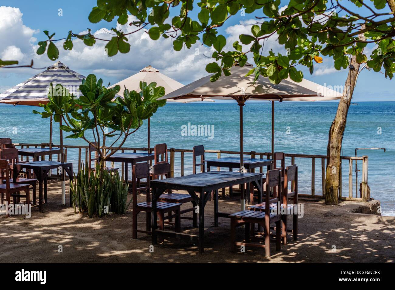 Batu Belig beach (Pantai Batu Belig), Badung, Bali, Indonesia. Beach cafe,  ocean view, umbrellas and trees Stock Photo - Alamy