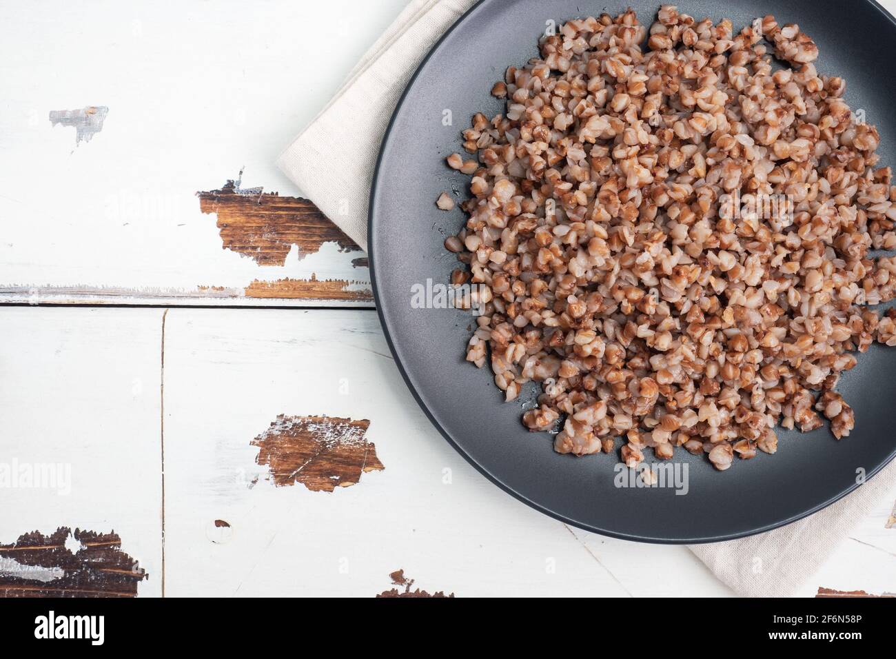 Boiled buckwheat on a plate. Healthy porridge enriched with vitamins copy space, top view. Stock Photo