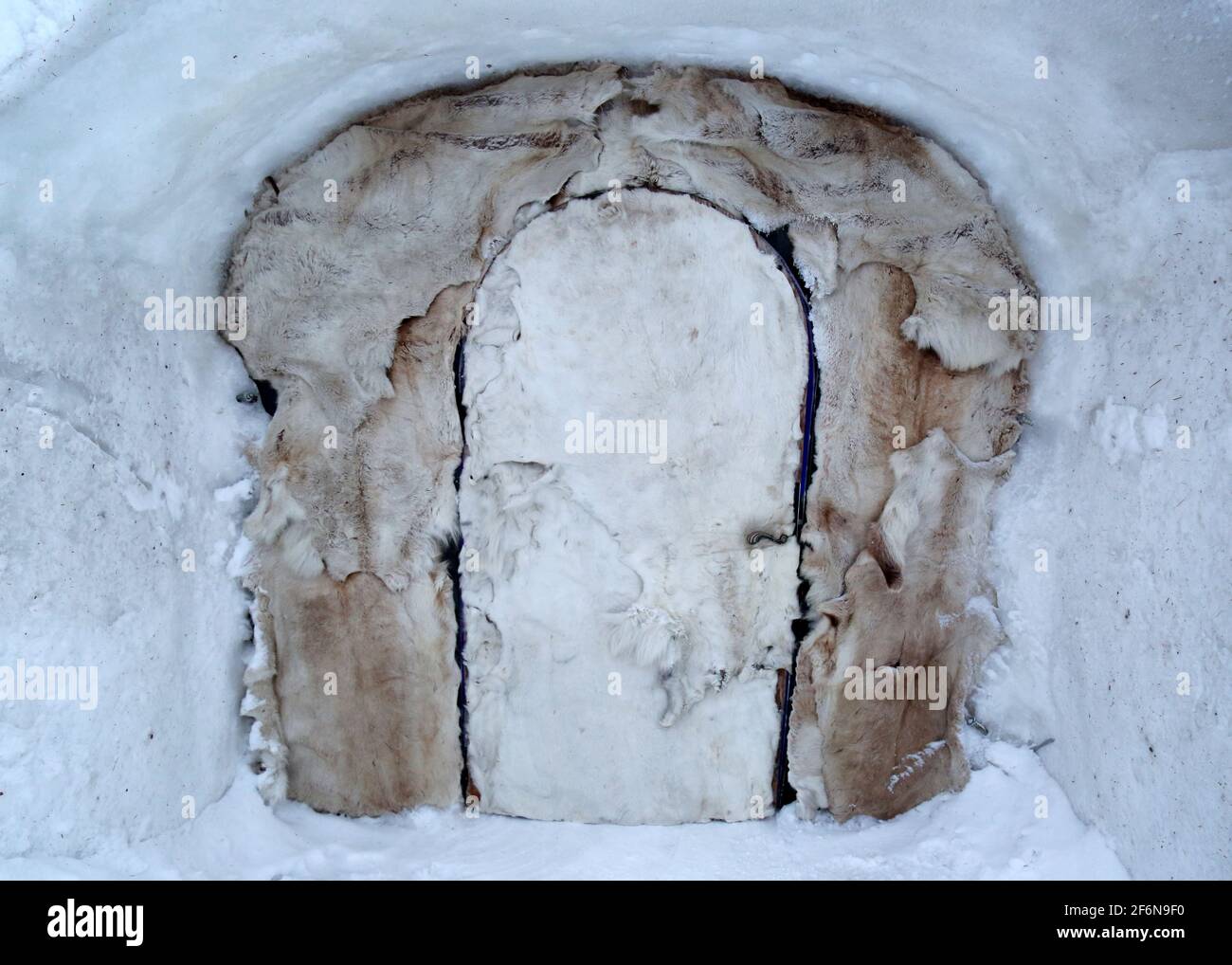 An abstract door covered in Arctic animals skins and pelts is seen on a snowy winter day at an ice lodge hotel in northern Norway, Scandinavia. Stock Photo