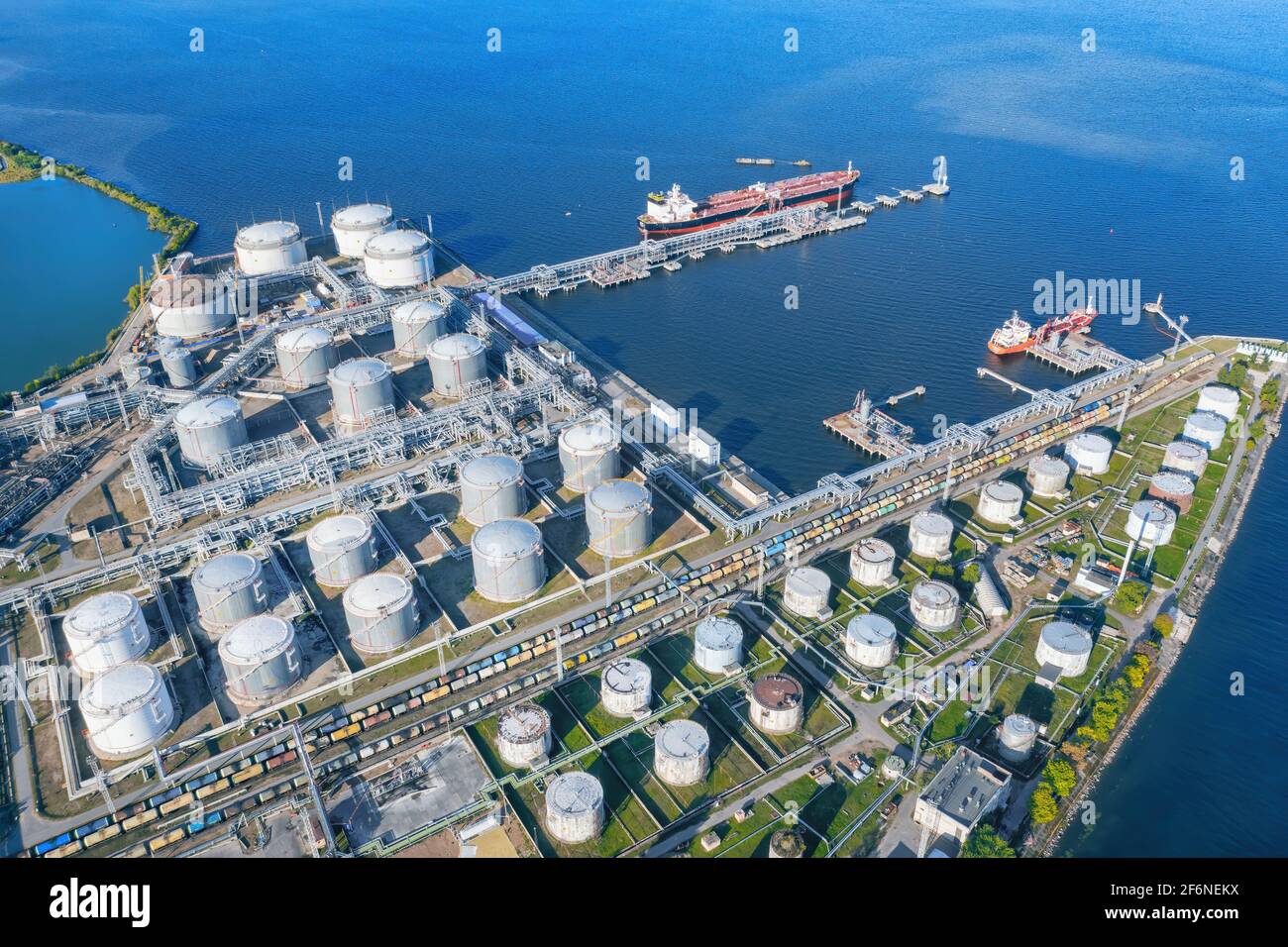 Oil terminal with a pier and a moored ship aerial view. Industrial landscape at sunny day Stock Photo