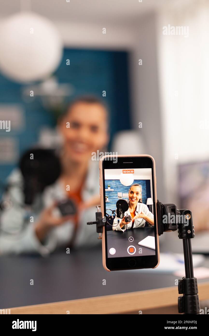 Close up of video blogger recording giveaway video for subscribers. Creative content creator social media star talking online about professional mouse at home studio podcast Stock Photo