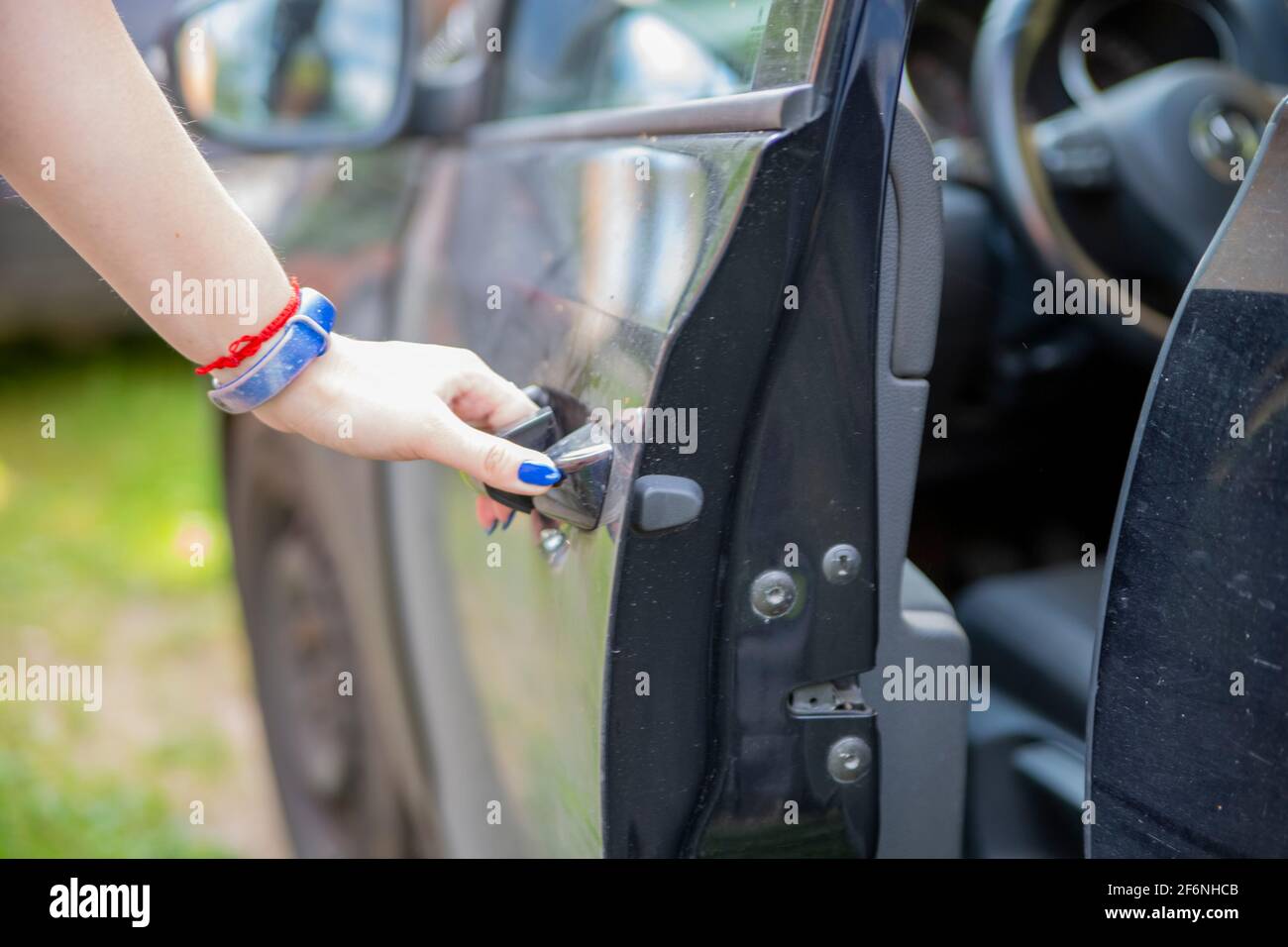 a woman's hand opens drivers door of a black car Stock Photo Alamy