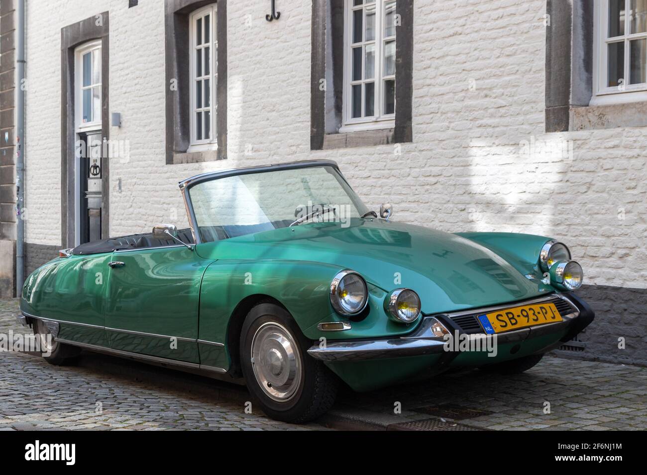 classical Citroën DS 21 car parked in the historical city centre of Maastricht. The car fits to the ancient environment and matches with cobblestones Stock Photo